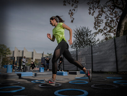 A woman jumps through the hoops at an outdoor exercise course in Paris, France