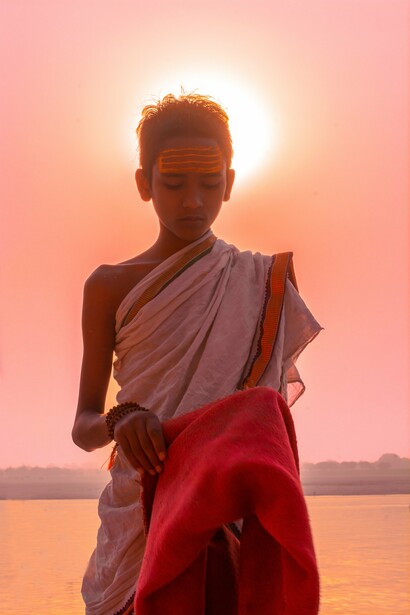 Hindu child standing, behind Ganges river, India