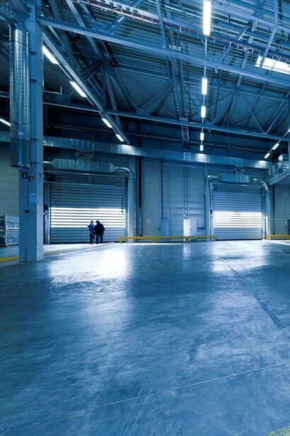 Men walk in a warehouse