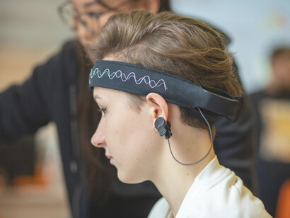 Close-up shot of a young woman wearing an electronic EEG headband