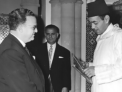 Delve into a momentous occasion as Dr. Abderrahmane Zniber receives his credentials from the esteemed hands of King Hassan II of Morocco. View this cherished memory captured in a scanned version of family photos from the Zniber Family Archives, courtesy of Amal Zniber