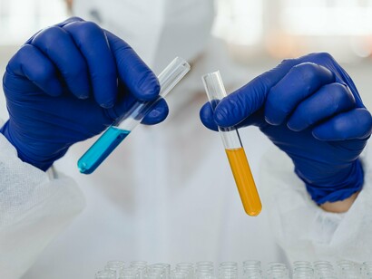 Mãos protegidas por luvas manipulam uma amostra em laboratório durante uma etapa de análise científica. É na pesquisa básica que muitas das descobertas capazes de originar futuras inovações começam a tomar forma