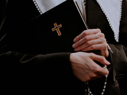 Mujer religiosa cargando una Biblia y un rosario