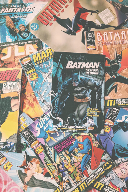 A delightful collection of comic books is elegantly arranged on the surface of a well-crafted table