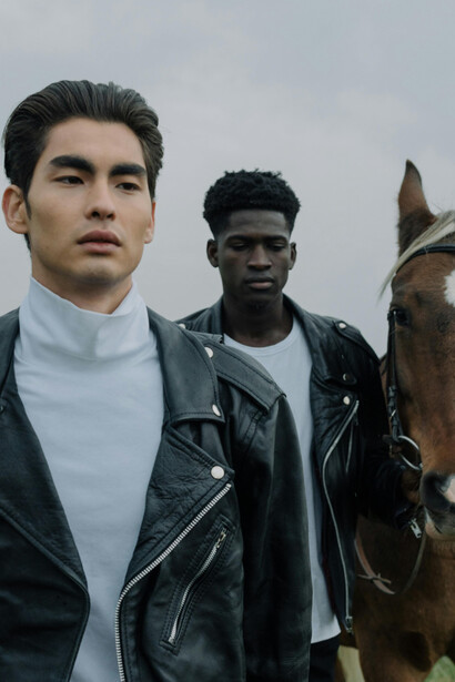 Young male fashion models photographed alongside a horse