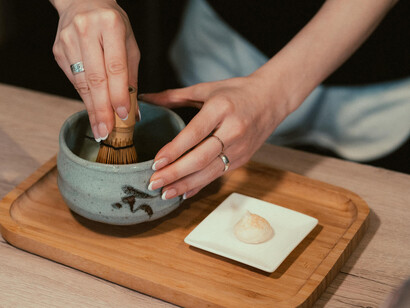 A person preparing matcha tea as part of a traditional ceremony