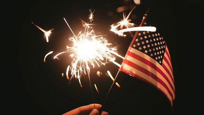 Capture the enchanting allure of sparklers against the backdrop of the American flag through mesmerizing time-lapse photography