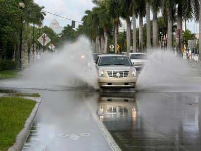 Un coche circula por una calle inundada en la costa de Florida