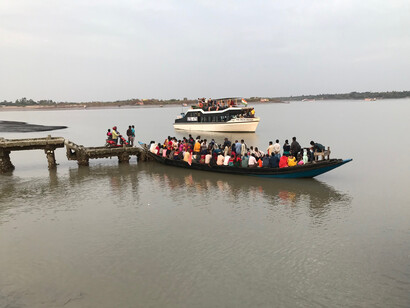 Dans la grande pirogue, qui navigue à travers le fleuve Gange en Inde, l'union des mains et de l'espoir reflète la lutte quotidienne contre les marées