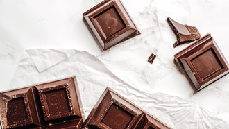 Barra de chocolate quebrada em quadradinhos sob a mesa