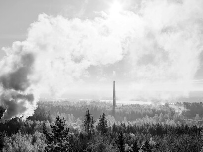 A serene winter landscape set against an industrial skyline, where calm natural beauty contrasts with looming human development