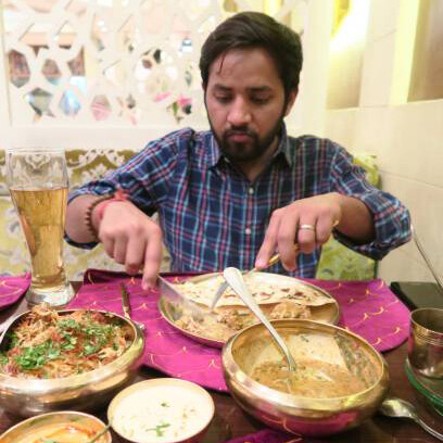 Hindu man dining at an Indian restaurant, savoring authentic Lucknowi biryani