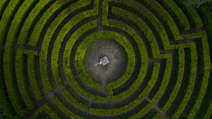 Porto, Portugal, a woman stands in the center of a labyrinth, framed by twisting paths and quiet symbolism