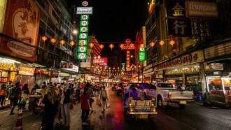 People walking along a street in Bangkok at night, Bangkok, Thailand