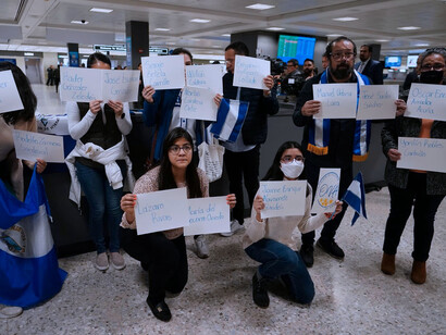 Un grupo de personas con los nombres de los presos políticos de Nicaragua en el aeropuerto de Dulles, Washington D. C.