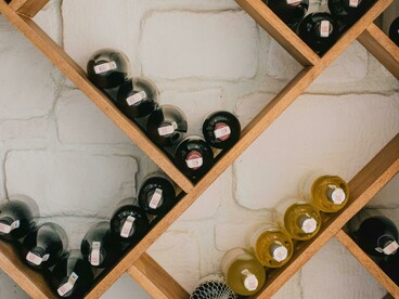 Wine bottles displayed on a rustic brown wooden shelf
