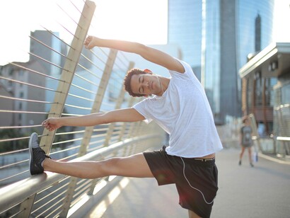 A man stretching while listening to music before he starts his exercises