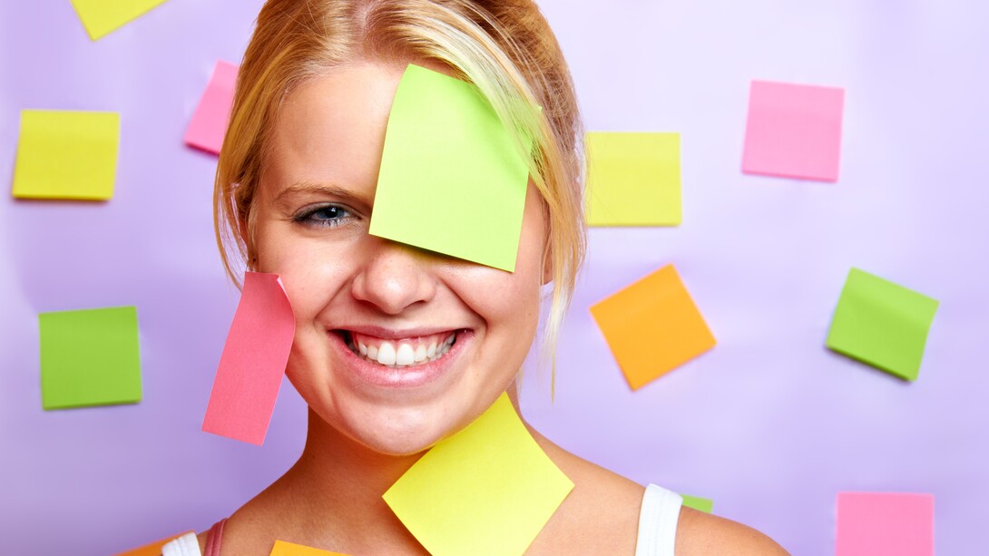 Una chica llena de etiquetas para recordar cosas