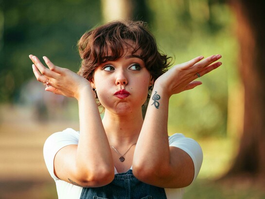 A playful woman outdoors striking a whimsical pose