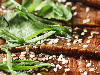 Prato com carne assada à moda coreana. Cada mesa tem sua própria churrasqueira a carvão e quem prepara a carne é você. Ao invés de cortes grandes como nossos bifes de picanha, no churrasco coreano a carne vem em fatias finas, para que você possa grelhar rapidamente na sua própria mesa, deixando tudo muito mais interativo e diferente