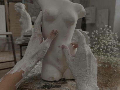 A sculpture creating a bust made out of clay