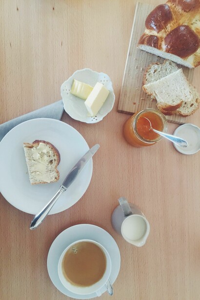 Frühstück mit Zopf, Butter und Marmelade