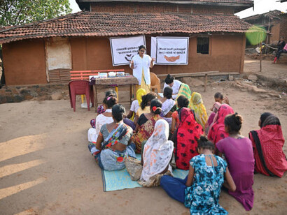 A female doctor leading a rural medical camp in India to raise awareness about women’s healthcare, focusing on public health advocacy, health inequities, and the role of neoliberalism in shaping health outcomes, while promoting social justice and human rights in the healthcare system