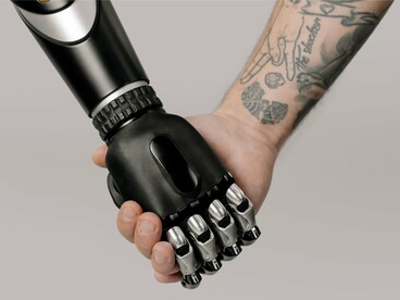 Human and robot holding hands, symbolising the future of human-AI collaboration in the workplace