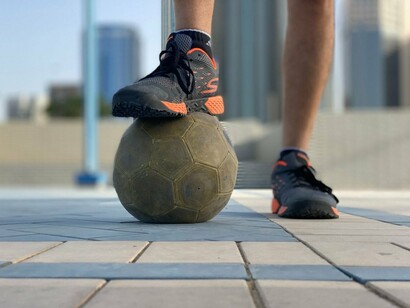 A football balanced beneath a player's foot, reflecting the foundation on which every future champion is built