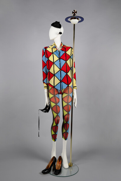 Harlequin print blouse with matching tights, mini tricorn hat, masquerade mask, patent
shoes and orb sceptre. Voyage to Cythera, AW 1989/90. © The Bowes Museum, County Durham. Photography by Claire Collinson