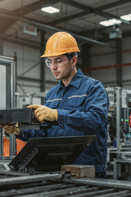 An engineer collaborates with a robotic assistant in a modern industrial facility, showcasing human-robot teamwork