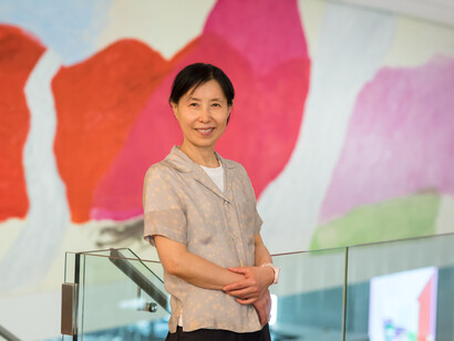 Jongsuk Yoon vor dem Wandgemälde Kumgangsan, 2024. Mit freundlicher Genehmigung des MUMOK. Foto von Klaus Pichle