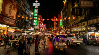 People walking along a street in Bangkok at night, Bangkok, Thailand