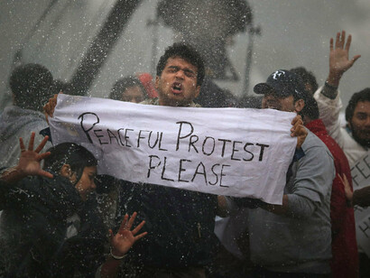 Manifestantes reaccionan contra oficiales de policía de la India  que usan un cañón de agua para dispersarlos cerca de la Puerta de India, ya que protestan contra la violación en grupo.