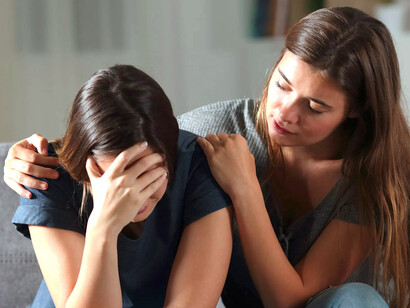 Mujer abraza a una amiga deprimida