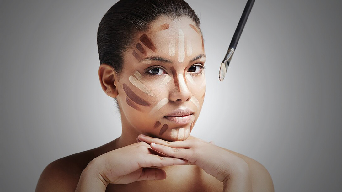 Woman with bold brows and corrector lines on her face, representing the 2010s beauty trends. Foundation makeup from the 2000s with heavy contouring