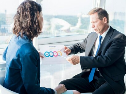A coach walking a client through a detailed infographic, highlighting the key milestones of the coaching journey, shows how dedication and strategic effort can help overcome the struggles of entrepreneurship