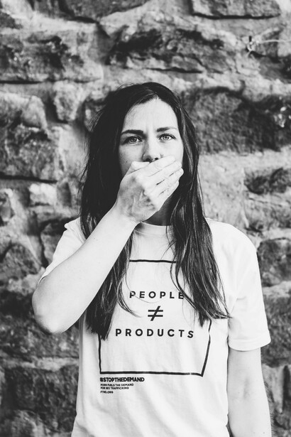 A woman covers her mouth so she can't speak out against what is happening