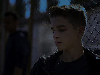 A young boy looked up in a juvenile center, looking sad and hopeless