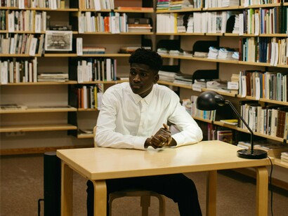 Homem em biblioteca. Conhecimento acadêmico: é o que envolve a experiência da teoria e prática, englobando a educação formal e demais titulações que se recebe ao longa da jornada