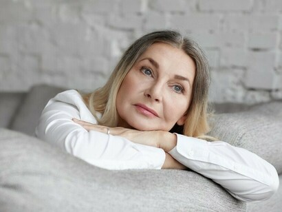 An expressive middle-aged woman posing with a stressed expression, representing hormonal transition in women