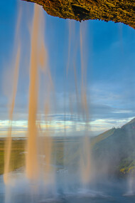 Vista lateral de la cascada Seljalandsfoss durante una puesta de sol, región de Suðurland, Islandia
