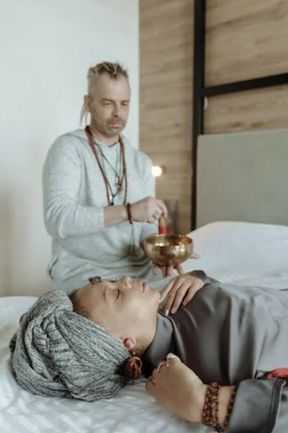 A couple resting on a bed, surrounded by elements of Ayurveda for relaxation and balance