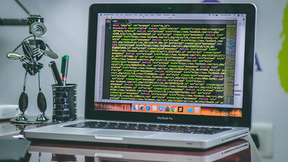 An open MacBook Pro displaying coding scripts, illustrating the integration of Web3 technologies