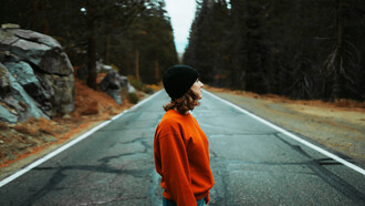 Mujer en mitad de la carretera admira el paisaje en el Parque Nacional de Yosemite, California, EE.UU.