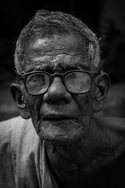 An older man wearing glasses looking at the camera