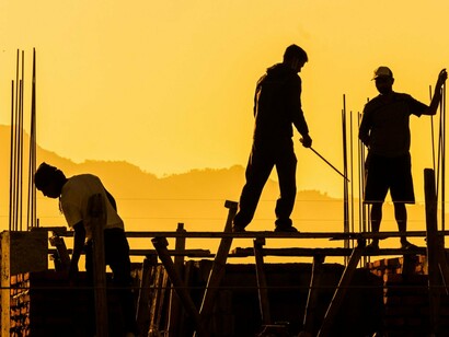 Workers working on a new structure, symbolizing the collective effort required to create a stronger future