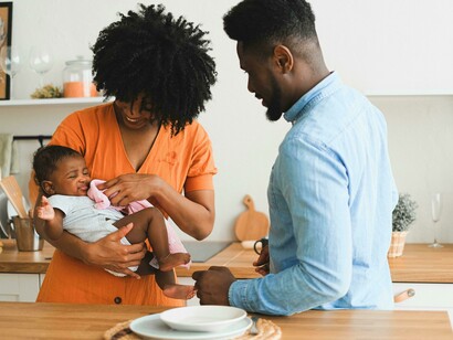 African American family holding their baby in a warm, affectionate moment