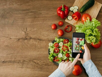 A person capturing images of vegetables with their smartphone, leveraging AI and genomic nutrition to receive tailored dietary recommendations for optimal health