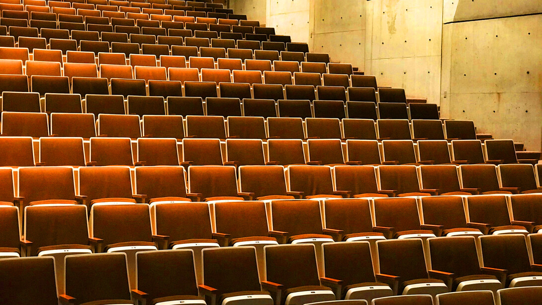 An atrium with empty seats; the author sees one filled with empty people 